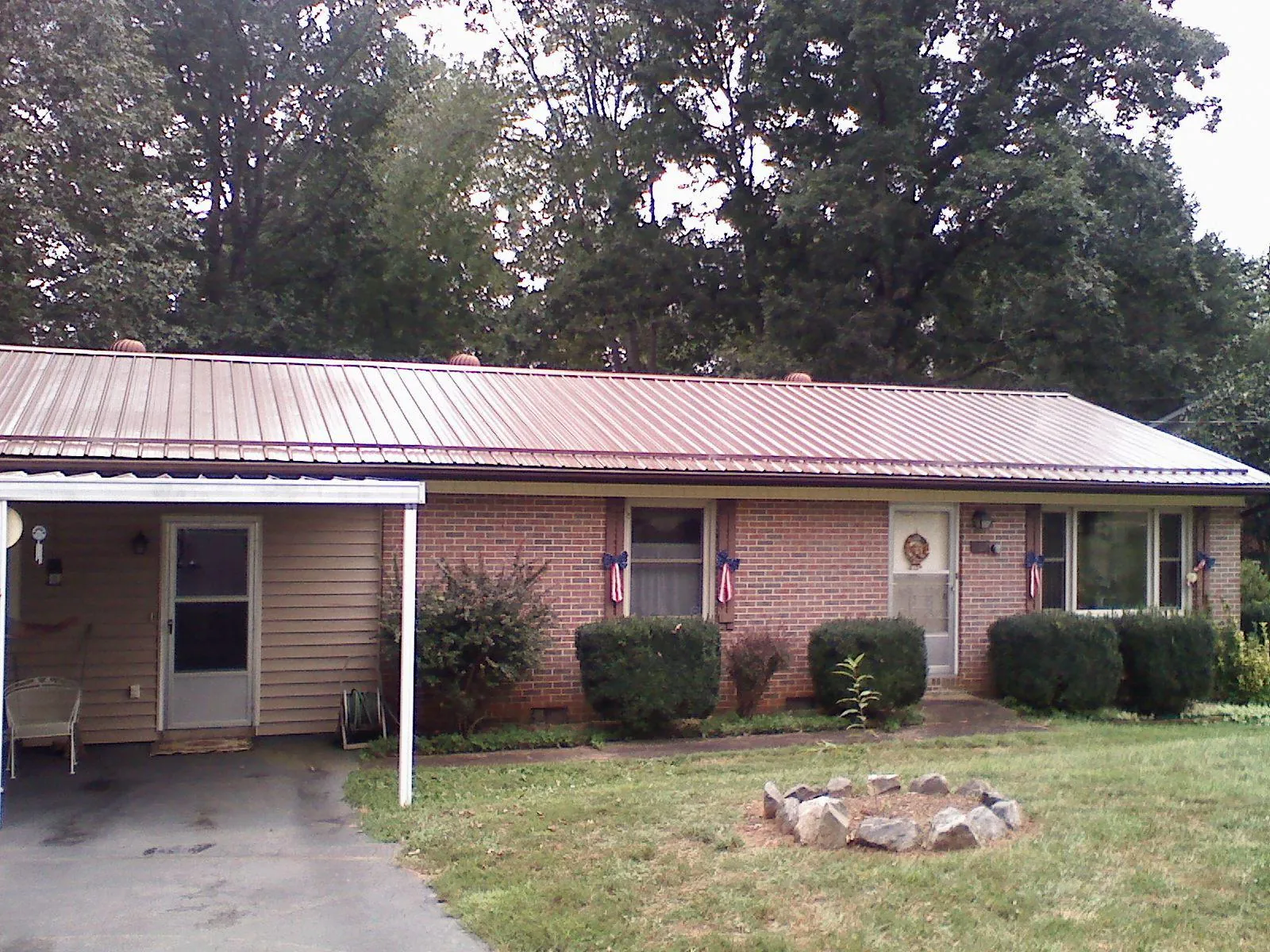Bronze metal roof and carport on a brick ranch home — Roof Repair work by our crew in Harrington
