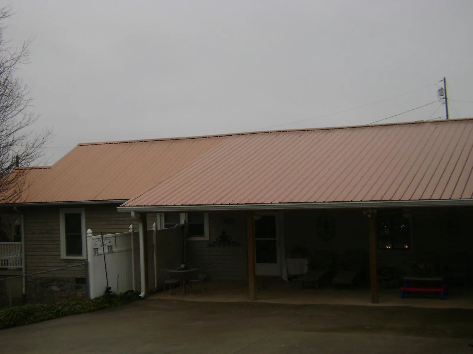 Copper toned metal roof over a wide covered patio in Harrington